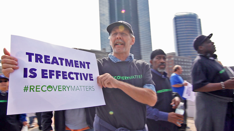 A man participates in a peaceful demonstration carrying a sign that says